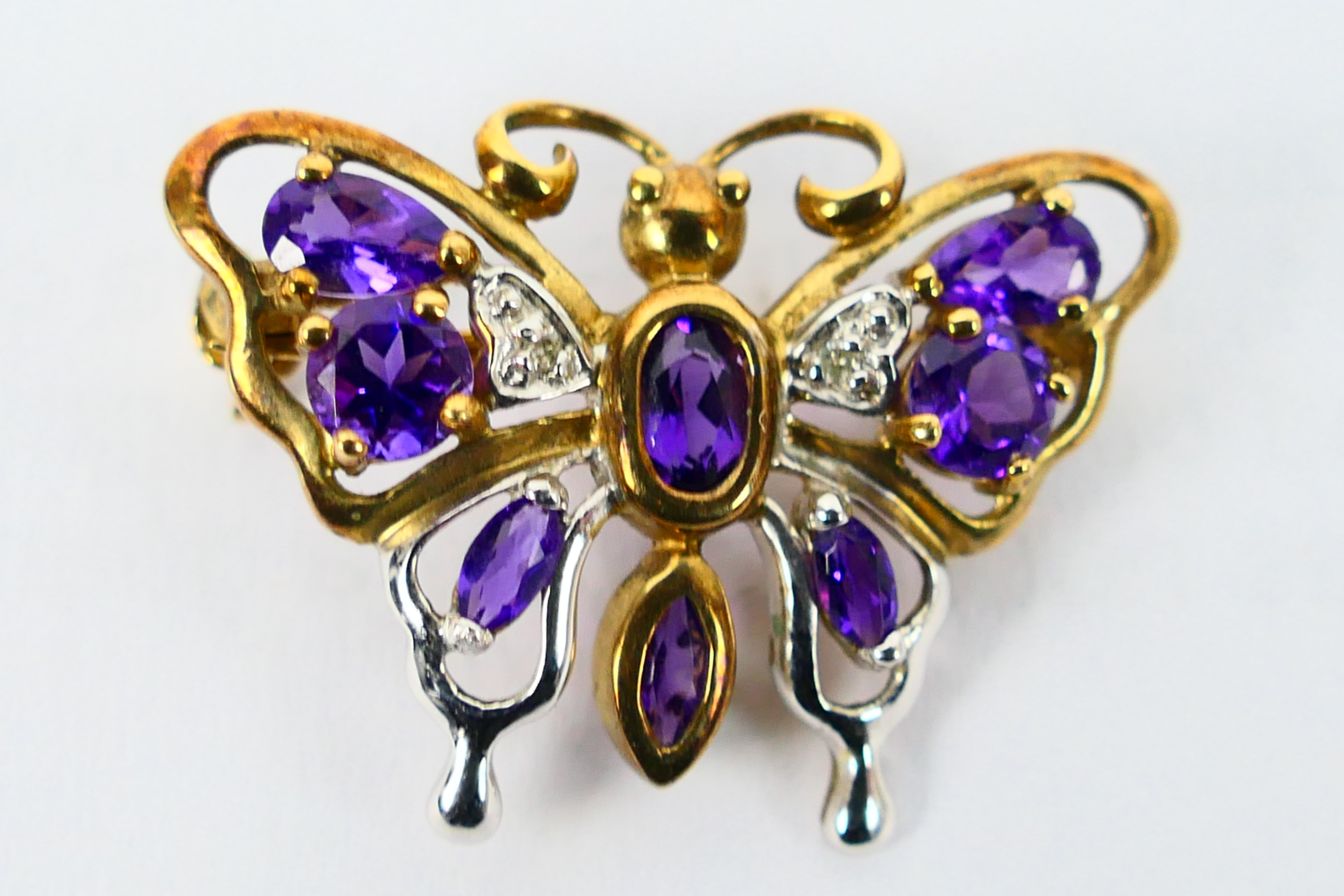 A 9ct gold, amethyst and diamond butterfly brooch, 2.5 cm wingspan, 2.8 grams.