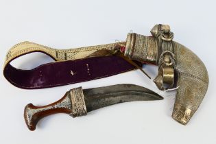 An early 20th century Middle Eastern jambiya dagger, white metal mounted wooden hilt,