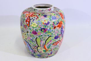 A large Japanese vase decorated with numerous butterflies amidst flora, signed to the base,