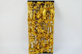 A Chinese carved gilt wood panel depicting numerous warriors engaged in battle,