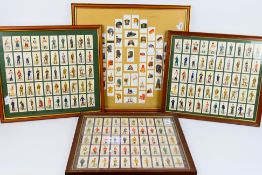 Four framed displays of military related cigarette cards, largest approximately 55 cm x 59 cm. [4].