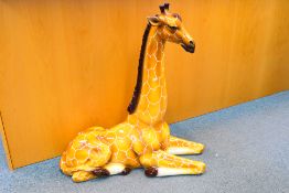 A large Italian ceramic study of a recumbent giraffe, approximately 90 cm (h).