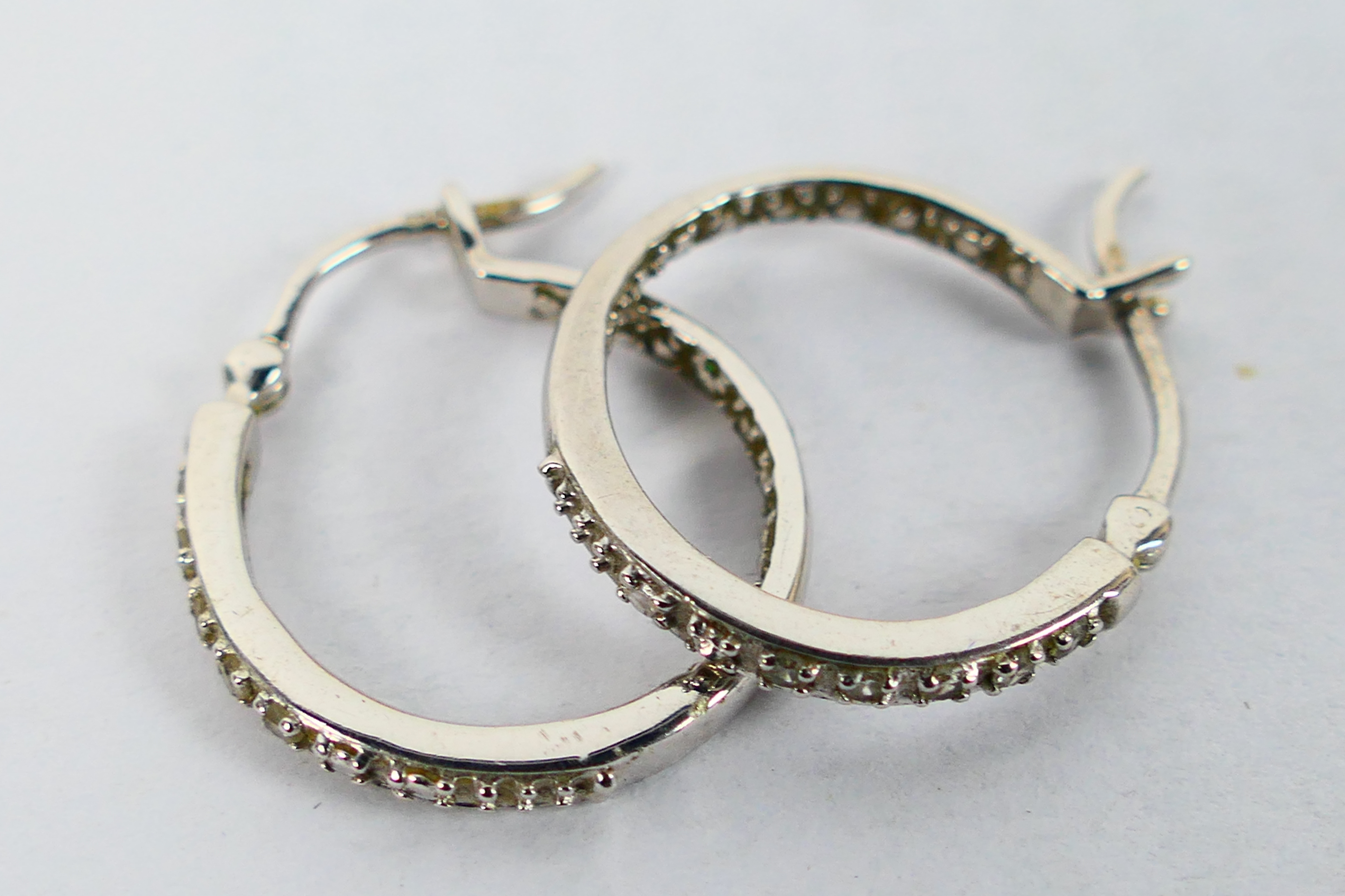 A pair of 9ct white gold, stone set ear hoops, approximately 2.7 grams.