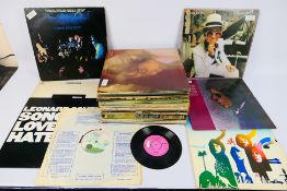 A collection of 12" vinyl records to include Bryan Adams, The Beach Boys, Cat Stevens,