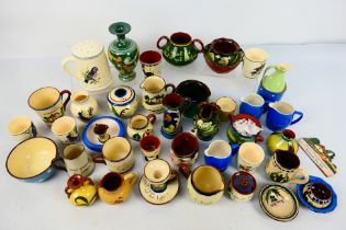 A collection of Torquay pottery wares to include bowls, jugs, cups,