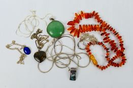 A collection of necklaces and pendants, predominantly stamped 925 with one amber chip example.