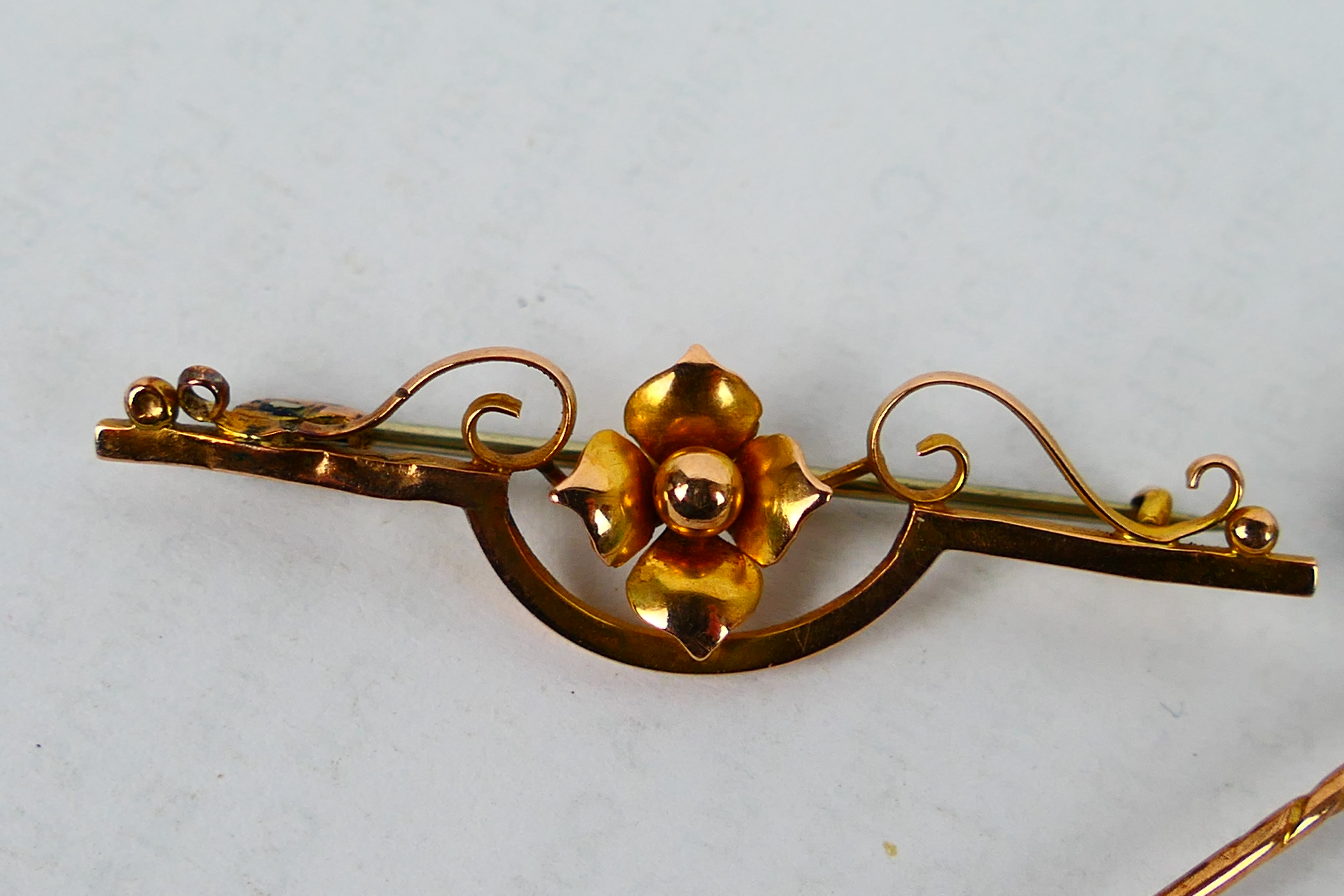 A yellow metal bar brooch with central floral motif, - Image 2 of 5