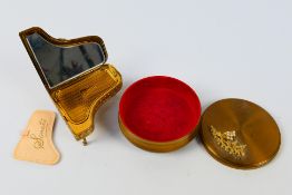 A vintage Pygmalion Sonata powder compact in the form of a piano and a trinket box.