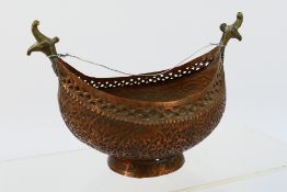 A copper kashkul or alms bowl with scroll decoration, approximately 19 cm (l).