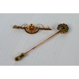 A yellow metal bar brooch with central floral motif,