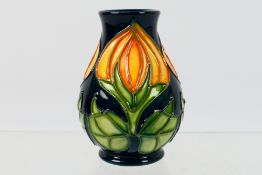 Moorcroft - A small Moorcroft Pottery vase decorated with orange flower buds, 1998,