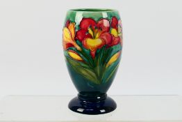 Moorcroft - A Moorcroft Pottery footed vase, decorated in the Freesia pattern,