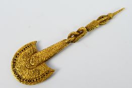 A yellow metal pendant in the form of a Polynesian war club, 9.5 cm (l).