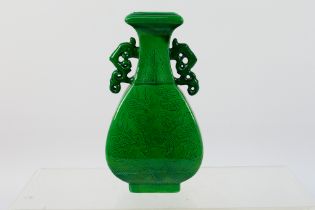 A small Chinese green glaze, twin handled vase, incised decoration depicting a Qilin,