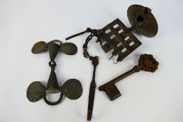 An 18th or 19th century iron oil burner, large bronze key and antique cast iron snaffle bit.