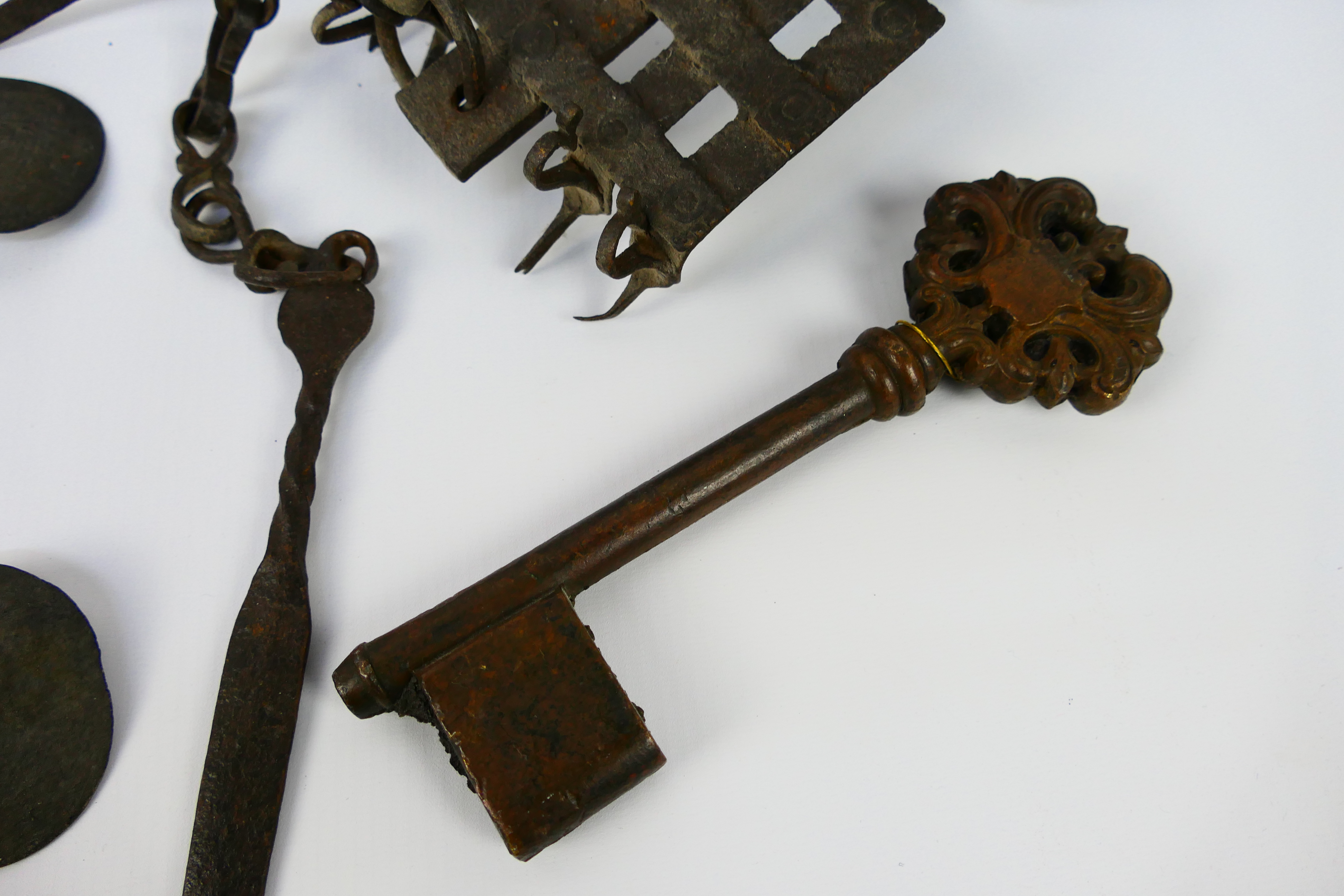 An 18th or 19th century iron oil burner, large bronze key and antique cast iron snaffle bit. - Image 4 of 4