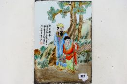 A Chinese famille rose rectangular plaque decorated with figures in a landscape setting,