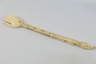 A bone back scratcher in the form of a hand,