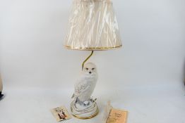 A decorative Franklin Mint table lamp with snowy owl form base designed by Raymond Watson,