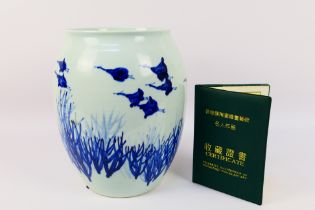 A Chinese blue and white Jingdezhen ware vase decorated with birds in flight, signed to the base,