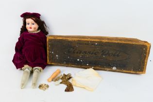 An early 20th century shoulder head dressed doll with fixed blue glass eyes, kid leather body,