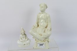 A blanc-de-chine figure depicting a seated male figure engaged in prayer or meditation,