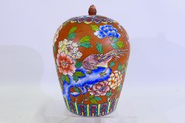 A large yixing pottery vase and cover decorated in enamels with depiction of perching birds amidst