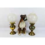 Two oil lamps and a ceramic study of a boxer dog, approximately 41 cm (h).