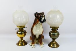 Two oil lamps and a ceramic study of a boxer dog, approximately 41 cm (h).