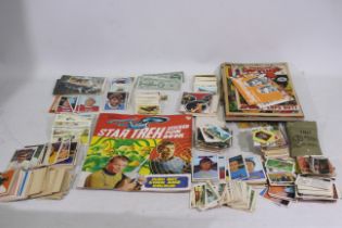 Lot to include tea cards, football trade cards, comics, Star Trek sticker book and similar.