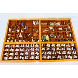 A wooden display housing a quantity of thimbles and small decorative ornaments, 53 cm x 83 cm.