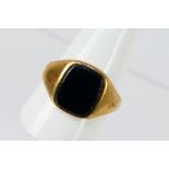 A 9ct yellow gold onyx ring, size X, approximately 5.5 grams.