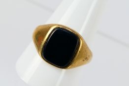 A 9ct yellow gold onyx ring, size X, approximately 5.5 grams.