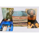 A collection of 12" vinyl records to include ABBA, Simon & Garfunkel and other.