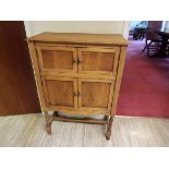 A small light oak cupboard having two sets of twin drawers to the front and flip top,