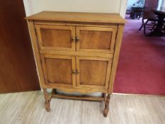 A small light oak cupboard having two sets of twin drawers to the front and flip top,