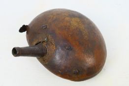 An antique leather clad powder flask, possibly Afghan or Indian, approximately 16 cm (l).