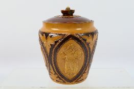 A Doulton Lambeth stoneware tobacco jar and cover decorated with imbibing monks,