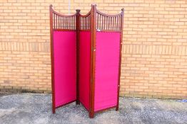 A three fold wood and upholstered screen / room divider, each panel approximately 195 cm x 61 cm.