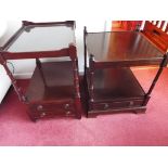 Two small dark wood tables with drawers below,