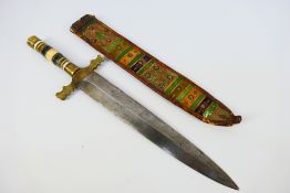 A late 19th or early 20th century North African short sword with brass, bone and wood hilt,