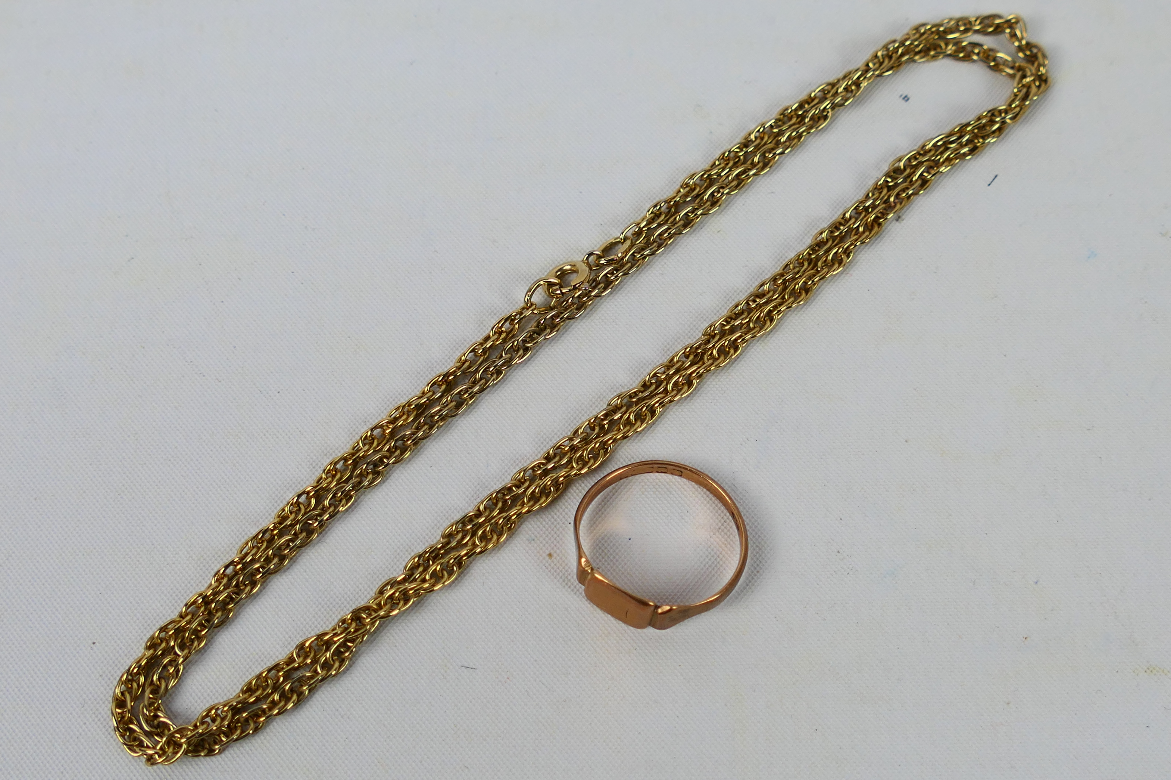 A rose gold ring (hallmarks very rubbed but presumed 9ct) and an unmarked yellow metal chain,