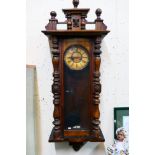 A Vienna-style wall clock. 124 cm (h) x 43 cm (w) x 20 cm (d), with key and pendulum.