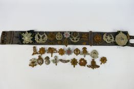 A collection of cap badges and similar insignia to include Royal East Kent, Rifle Brigade,
