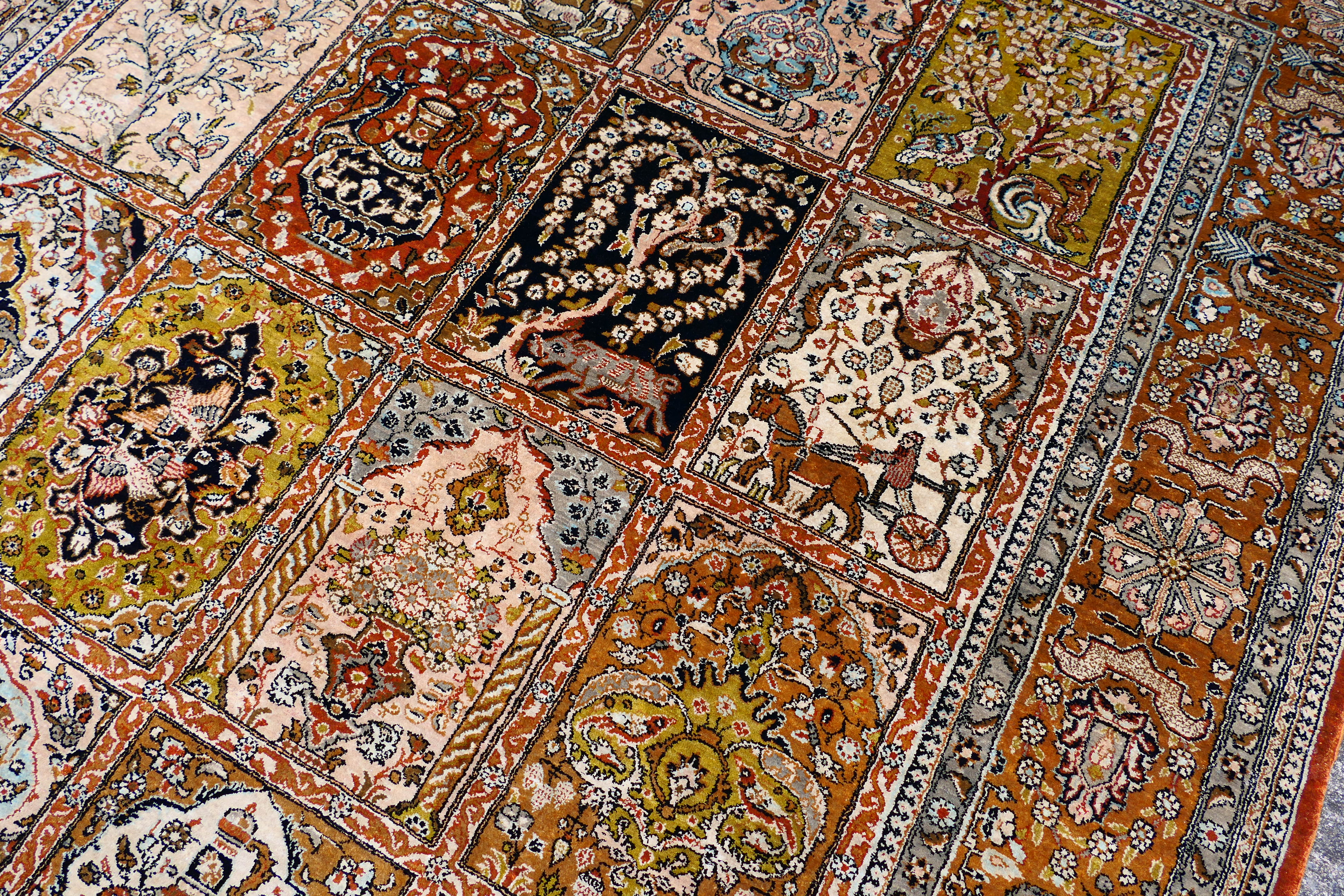 A Persian rug decorated with panels of flowering urns, - Image 15 of 17