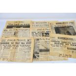 A collection of vintage newspapers with front pages detailing historically significant events to