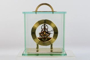 Seiko - A glass cased skeleton clock with quartz movement, 24 cm (h) to top of handle.