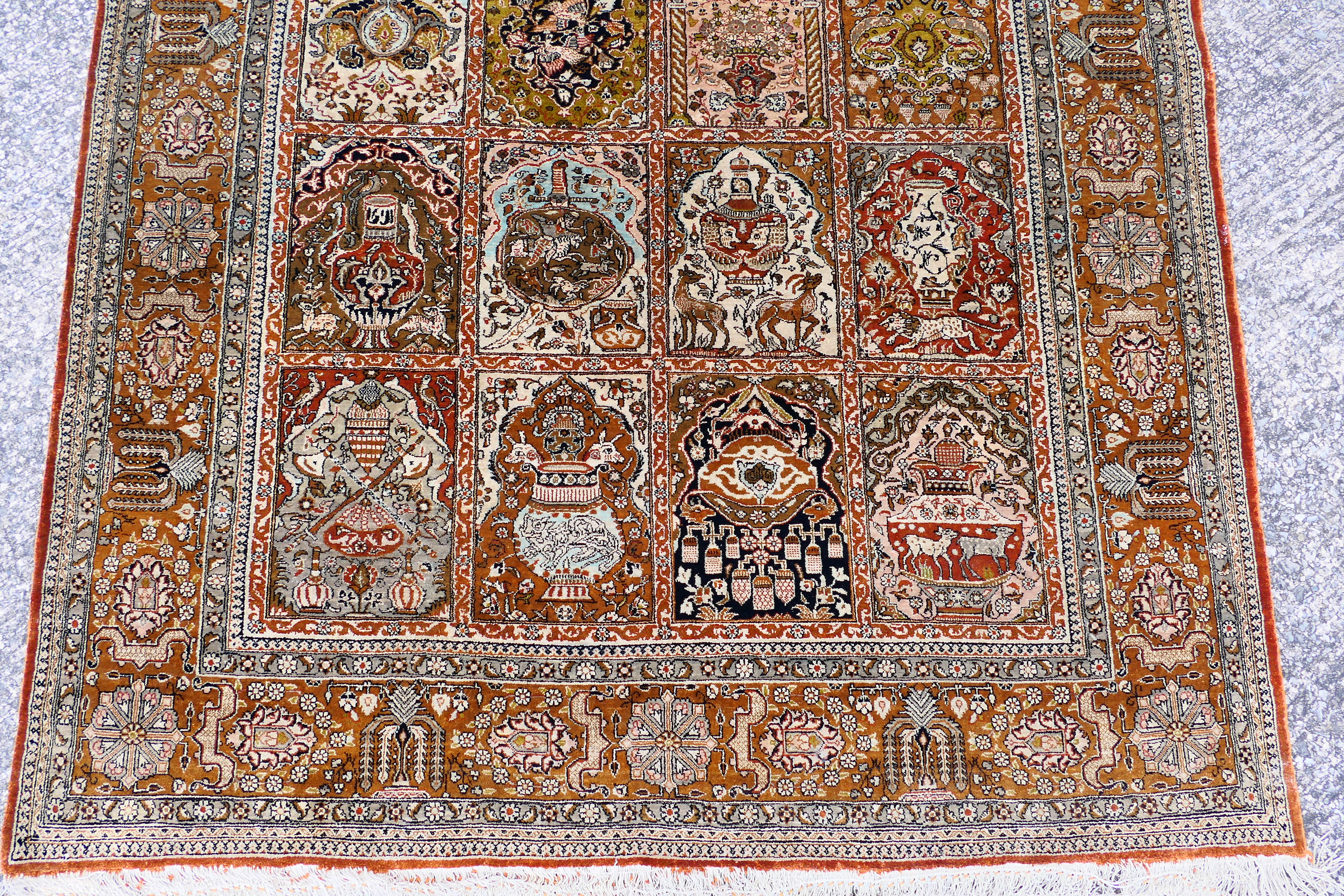 A Persian rug decorated with panels of flowering urns, - Image 2 of 17