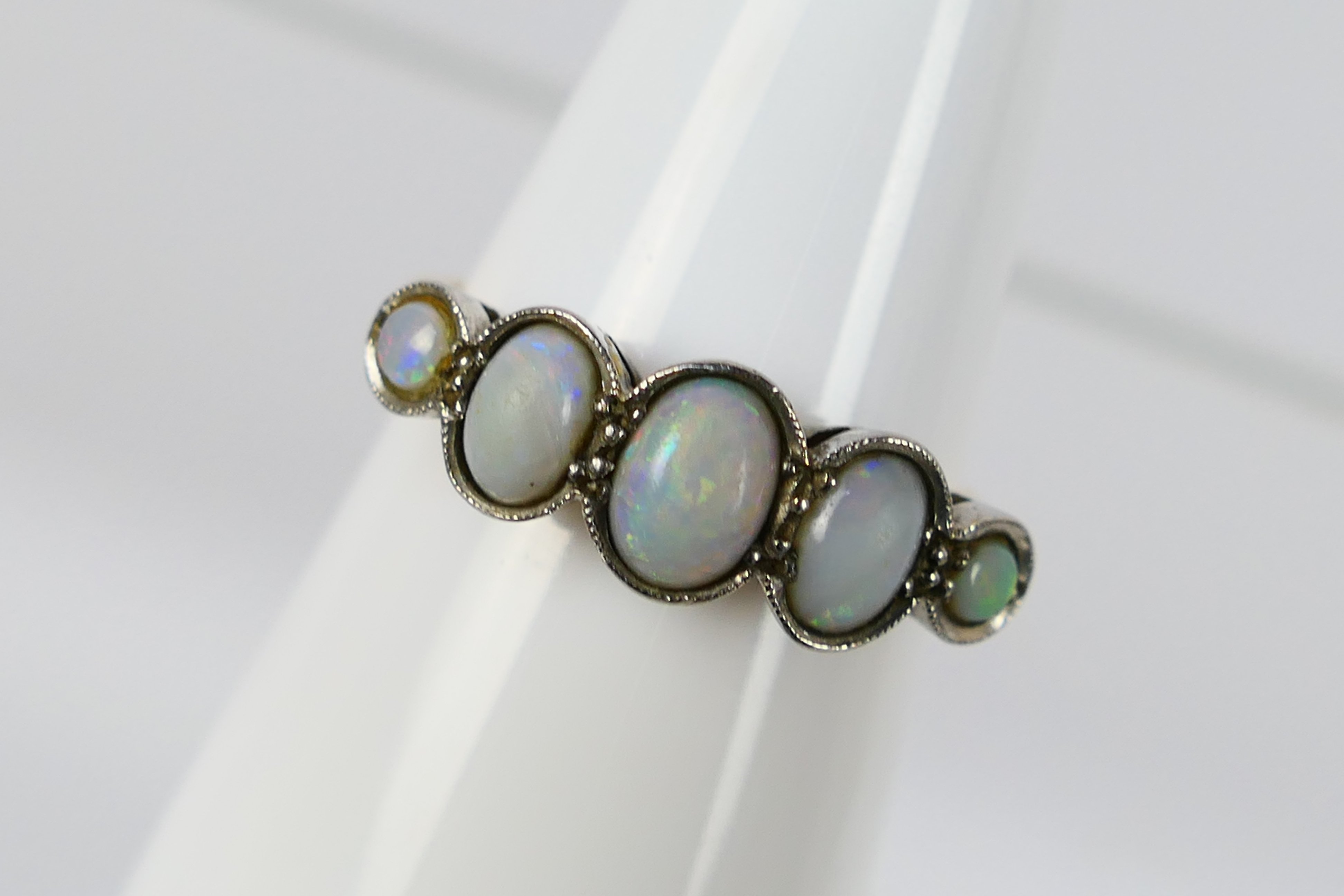 A five stone opal ring, stamped 18ct PLAT, size N+½, 3.2 grams. - Image 2 of 6