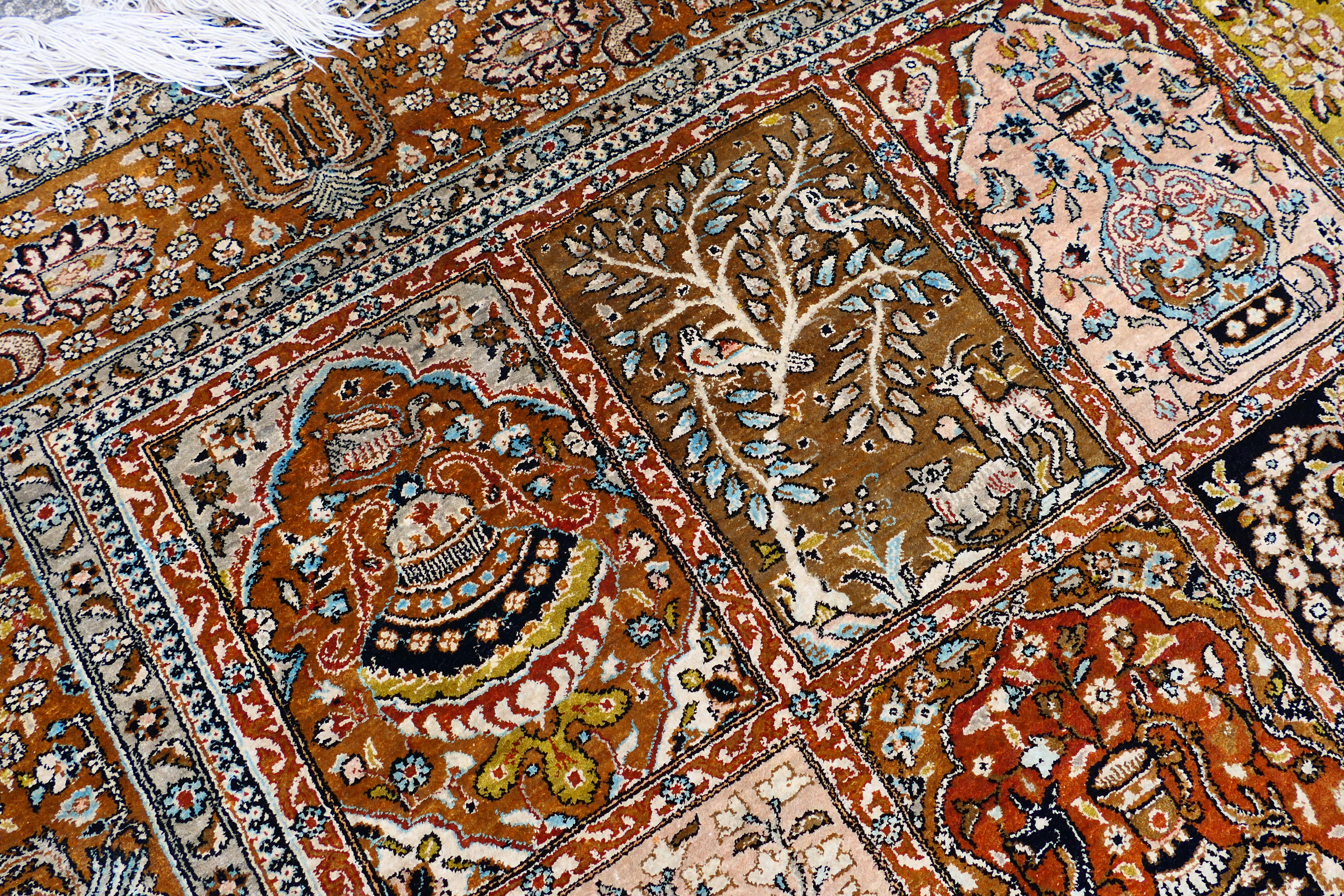 A Persian rug decorated with panels of flowering urns, - Image 10 of 17